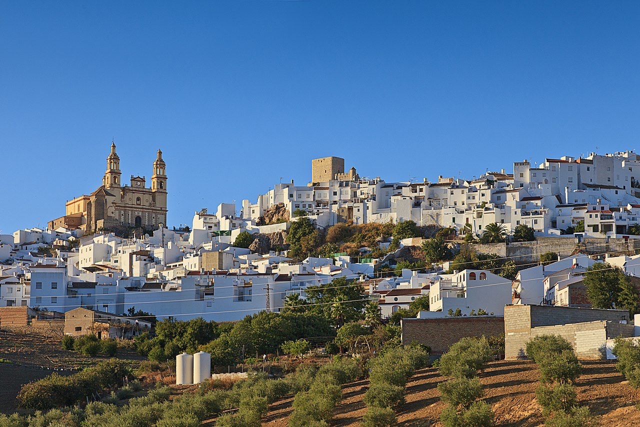 Weißes andalusisches Dorf auf einem Hügel mit maurischer Festung obenauf